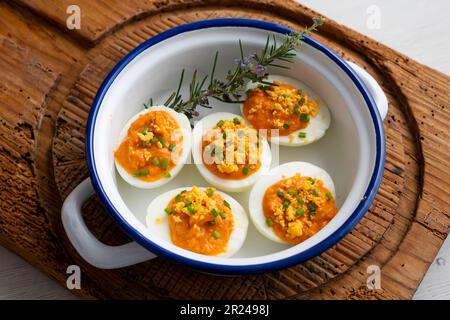 Œufs farcis à la crème de thon et de tomate. Recette traditionnelle de tapa espagnole. Banque D'Images