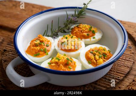 Œufs farcis à la crème de thon et de tomate. Recette traditionnelle de tapa espagnole. Banque D'Images