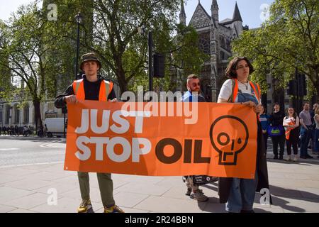 Londres, Royaume-Uni. 17th mai 2023. Les manifestants tiennent une bannière tandis que les policiers arrêtent les activistes du secteur pétrolier Just Stop sur la place du Parlement. Le groupe climatique poursuit sa marche lente quotidienne exigeant que le gouvernement cesse d'émettre de nouvelles licences de pétrole et de gaz. Credit: Vuk Valcic/Alamy Live News Banque D'Images