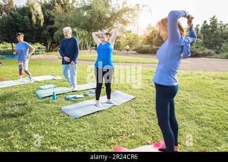 Personnes âgées multiraciales faisant des exercices d'entraînement en plein air avec parc de la ville en arrière-plan - mode de vie sain et joyeuse vieux concept de style de vie - Focu Banque D'Images