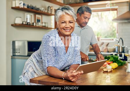 Portrait de la vieille femme dans la cuisine avec l'homme, une tablette et cuisiner ensemble des aliments sains à la maison. Recette numérique, sourire et couple senior dans la maison avec Banque D'Images