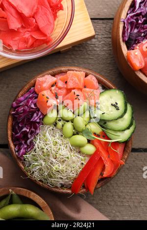 Délicieux poke bols avec des légumes, du poisson et des haricots édamames sur une table en bois, plat Banque D'Images