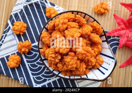 Craquelins de riz japonais enrobés de sauce soja - en-cas japonais de finger food appelé Otsumami ou Age Arare à la vue de dessus sur le platemat de bambou Banque D'Images