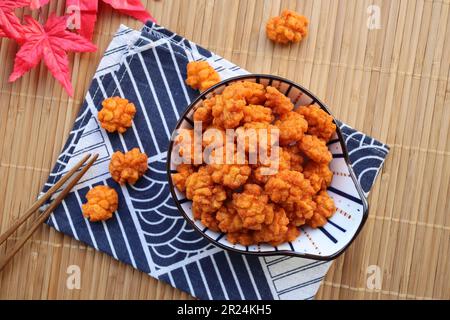 Craquelins de riz japonais enrobés de sauce soja - en-cas japonais de finger food appelé Otsumami ou Age Arare à la vue de dessus sur le platemat de bambou Banque D'Images