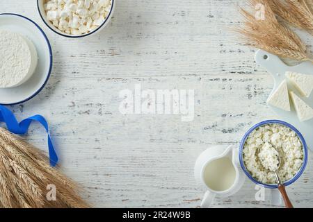 Fête juive de Shavuot. Kasher produits laitiers frais lait et fromage, blé mûr, crème sur fond de bois blanc. Les produits laitiers sur le whi Banque D'Images