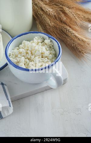 Fête juive de Shavuot. Kasher produits laitiers frais lait et fromage, blé mûr, crème sur fond de bois blanc. Les produits laitiers sur le whi Banque D'Images