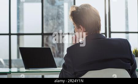 Vue arrière portrait homme d'affaires assis au bureau sur le lieu de travail Banque D'Images
