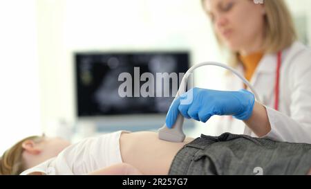 Médecin du diagnostic échographique faisant l'échographie du foie et des voies biliaires à l'enfant en clinique de près Banque D'Images