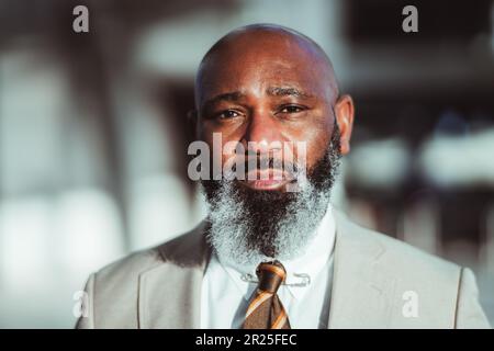 Lisbonne ; Un portrait en gros plan d'un charmant homme noir avec une longue barbe montrant des signes de vieillissement, vêtu d'une veste de costume grise, capturée avec sélectif f Banque D'Images