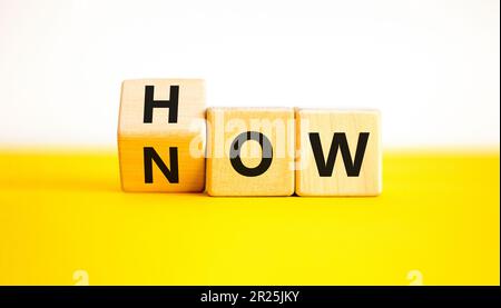 Symbole savoir-faire. L'homme d'affaires tourne des cubes en bois et change le mot Comment savoir. Magnifique table jaune fond blanc. Copier l'espace. Affaires et kn Banque D'Images
