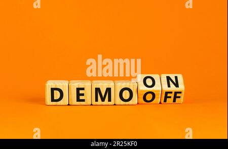 Symbole Démo activé ou désactivé. Homme d'affaires transforme les cubes en bois et le mot Démo désactivé en Démo activée. Belle table orange fond orange. Affaires et dem Banque D'Images