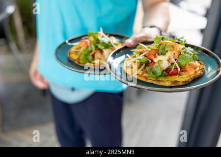 Assiette pour serveur avec salade fraîche sur un pain plat grillé au restaurant Banque D'Images