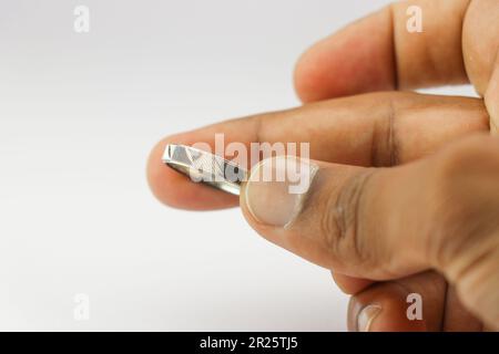 Bague argentée avec de beaux motifs tenus dans la main sur un fond blanc Banque D'Images