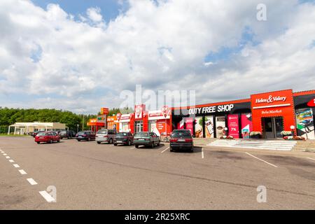 Bruzgi, Bélarus - 11 août 2019: Les voitures franchissant la frontière sont garées à proximité de magasins en zone hors taxes au point de contrôle de Bruzgi Banque D'Images