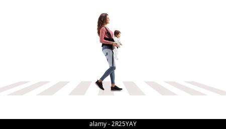 Prise de vue sur toute la longueur d'une jeune mère avec un babababay dans un porteur marchant à la traversée piétonne isolée sur fond blanc Banque D'Images