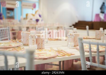 Table de fête sur le thème du carnaval ou du carrousel pour enfants avec assiettes en plastique et bonbons. Décoration festive pour une fête d'anniversaire de petite fille avec déjeuner ta Banque D'Images