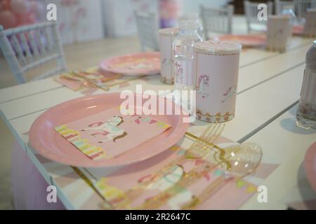 Table de fête sur le thème du carnaval ou du carrousel pour enfants avec assiettes en plastique et bonbons. Décoration festive pour une fête d'anniversaire de petite fille avec déjeuner ta Banque D'Images