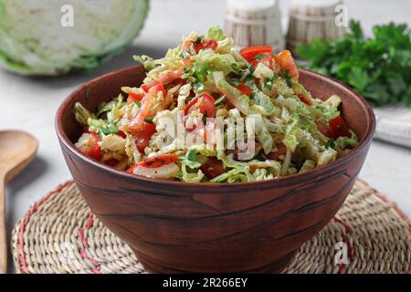 Salade au chou de savoie, tomates et persil dans un bol brun, gros plan Banque D'Images