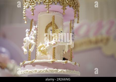 Gâteau d'anniversaire décoration carrousel gros plan. Un joli gâteau énorme avec des détails de carnaval du sucre glace. Gâteau au carrousel à cheval Banque D'Images