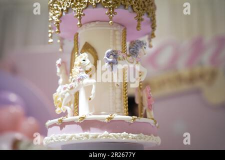 Gâteau d'anniversaire décoration carrousel gros plan. Un joli gâteau énorme avec des détails de carnaval du sucre glace. Gâteau au carrousel à cheval Banque D'Images