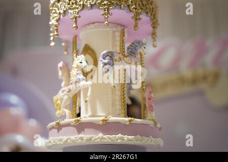 Gâteau d'anniversaire décoration carrousel gros plan. Un joli gâteau énorme avec des détails de carnaval du sucre glace. Gâteau au carrousel à cheval Banque D'Images