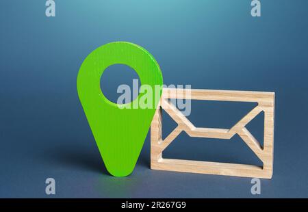 Symbole d'enveloppe et signe de géolocalisation en vert. Envoi ou réception d'informations, de messages ou de notifications dans un contexte géographique. Respect de l'environnement Banque D'Images