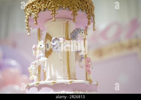 Gâteau d'anniversaire décoration carrousel gros plan. Un joli gâteau énorme avec des détails de carnaval du sucre glace. Gâteau au carrousel à cheval Banque D'Images