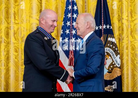 Washington, États-Unis d'Amérique. 17th mai 2023. Washington, États-Unis d'Amérique. 17 mai 2023. Le président américain Joe Biden, à droite, félicite le pompier de New York Patrick Thornton de la Médaille de la sécurité publique de Valor lors d'une cérémonie dans la salle est de la Maison Blanche, à 17 mai 2023, à Washington, DC la médaille est la plus haute décoration du pays pour un agent de sécurité publique pour des actes de bravoure. Crédit : Adam Schultz/White House photo/Alay Live News Banque D'Images