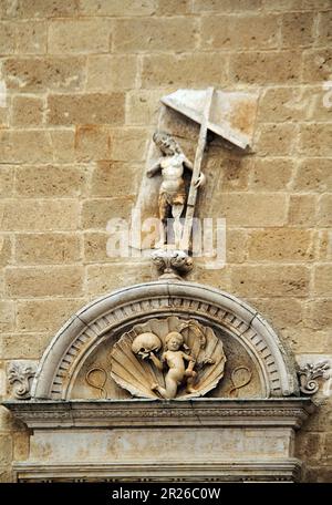 Gravina, Italie. Extérieur du côté ouest de la cathédrale catholique romaine. Frontispice d'une porte latérale, avec une statue du Christ ressuscité. Banque D'Images