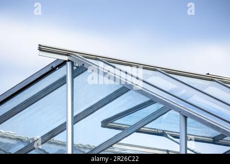 Serre fait de verre et de métal cadre est sous ciel bleu clair, photo d'arrière-plan Banque D'Images