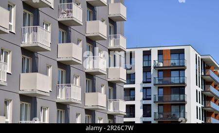 Immeuble d'appartements aux façades lumineuses. Architecture moderne minimaliste avec de nombreuses fenêtres en verre et balcons. Banque D'Images