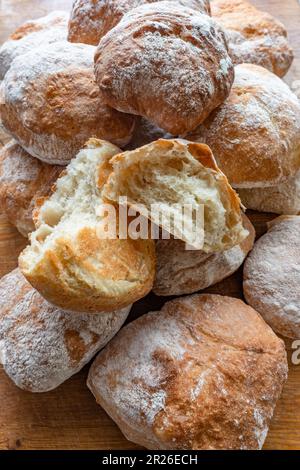 Une pile de petits pains faits maison frais ciabatta blancs et croustillants sur une table rustique en bois, vue sur le dessus, vue latérale. Banque D'Images