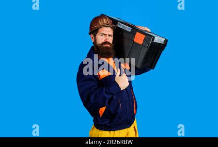 Réparer la maison. Réparateur dans un casque de sécurité avec boîte à outils montrant le pouce vers le haut. Homme de main, artisan avec kit de réparation. Construction sérieuse en uniforme avec boîte à outils Banque D'Images