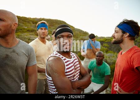 Plus la lutte est forte, plus le triomphe est glorieux. Portrait d'un jeune homme au camp d'entraînement avec ses amis. Banque D'Images