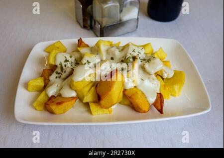 Pommes de terre rôties de style asturien avec fromage bleu fondu cabrales du village de Las Arenas, Asturies, Espagne Banque D'Images