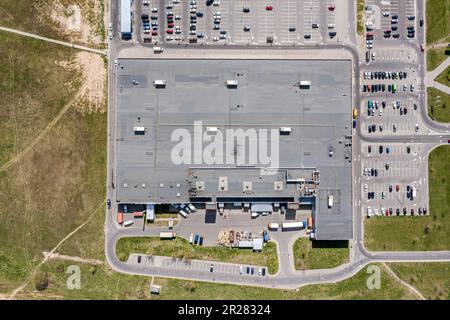 le toit en bardeaux du centre commercial est équipé de systèmes de ventilation et d'un parking avec voitures garées. vue de dessus de l'antenne. Banque D'Images