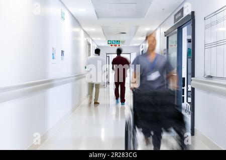 Mouvement flou de divers médecins et du personnel médical dans le couloir occupé de l'hôpital, l'espace de copie Banque D'Images