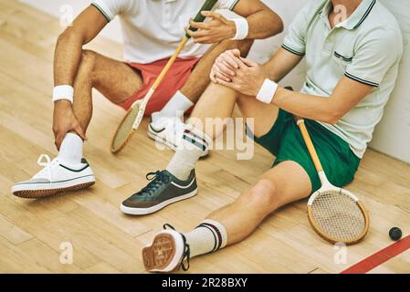 Après un bon jeu, vient un bon refroidissement. deux hommes prenant une pause après avoir joué à une partie de squash. Banque D'Images