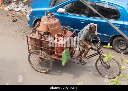 Howrah, Bengale-Occidental, Inde - 20 mars 2023 : un livreur indien transportant une bouteille GPL Indane dans sa camionnette de livraison Banque D'Images