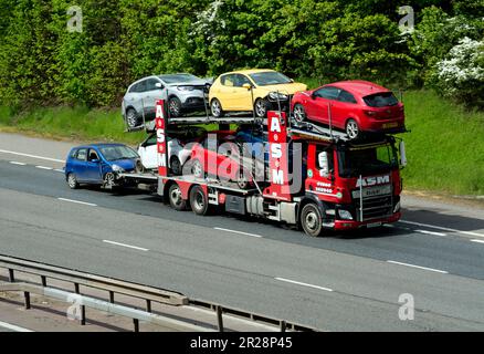 Camion ASM transportant des voitures endommagées par accident sur l'autoroute M40, Warwickshire, Royaume-Uni Banque D'Images