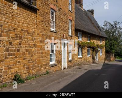 Maisons de chaume construites en pierre de couleur miel locale dans le village de Hardingstone, Northampton, Royaume-Uni Banque D'Images
