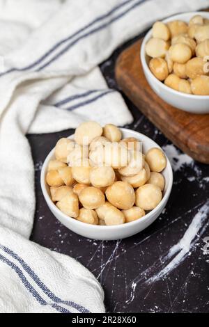 Noix de macadamia. Noix de macadamia pelées dans un bol en céramique. super-alimentation. Concept de cuisine végétarienne. des collations saines Banque D'Images