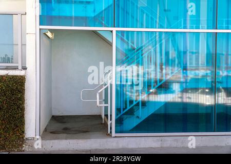 Entrée d'un bâtiment avec escalier et grandes fenêtres de teinte bleue. Banque D'Images
