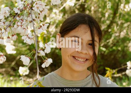 Fille sous un cerisier en fleur. Banque D'Images