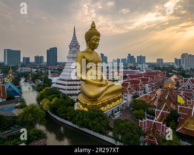 Un bateau passait devant la statue du Grand Bouddha (Phra Bouddha Dhammakaya Thepmongkhon ) dans le temple Wat Pak Nam Phasi Charoen situé près de la rivière au coucher du soleil. Banque D'Images