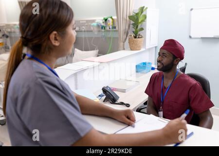 Divers médecins et infirmières de sexe masculin écrivant et parlant à l'hôpital Banque D'Images