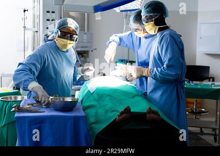 Divers groupes de chirurgiens opérant sur le patient dans le bloc opératoire Banque D'Images