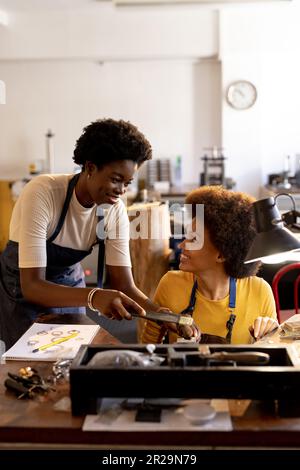 Joyeux ouvriers divers faisant des bijoux en utilisant des outils à l'atelier de bijoux Banque D'Images