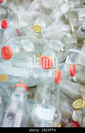 Bouteilles en verre vides utilisées stockées pour recyclage, mise au point sélective. Banque D'Images