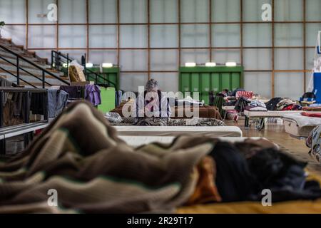 Castel Bolognese, Italie. 18th mai 2023. Une femme âgée s'assoit sur un lit dans un gymnase utilisé comme abri pour les victimes des inondations. La région italienne d'Émilie-Romagne a connu des inondations dévastatrices qui ont coûté la vie à au moins neuf personnes le long de la côte Adriatique du pays. Credit: Oliver Weiken/dpa/Alay Live News Banque D'Images